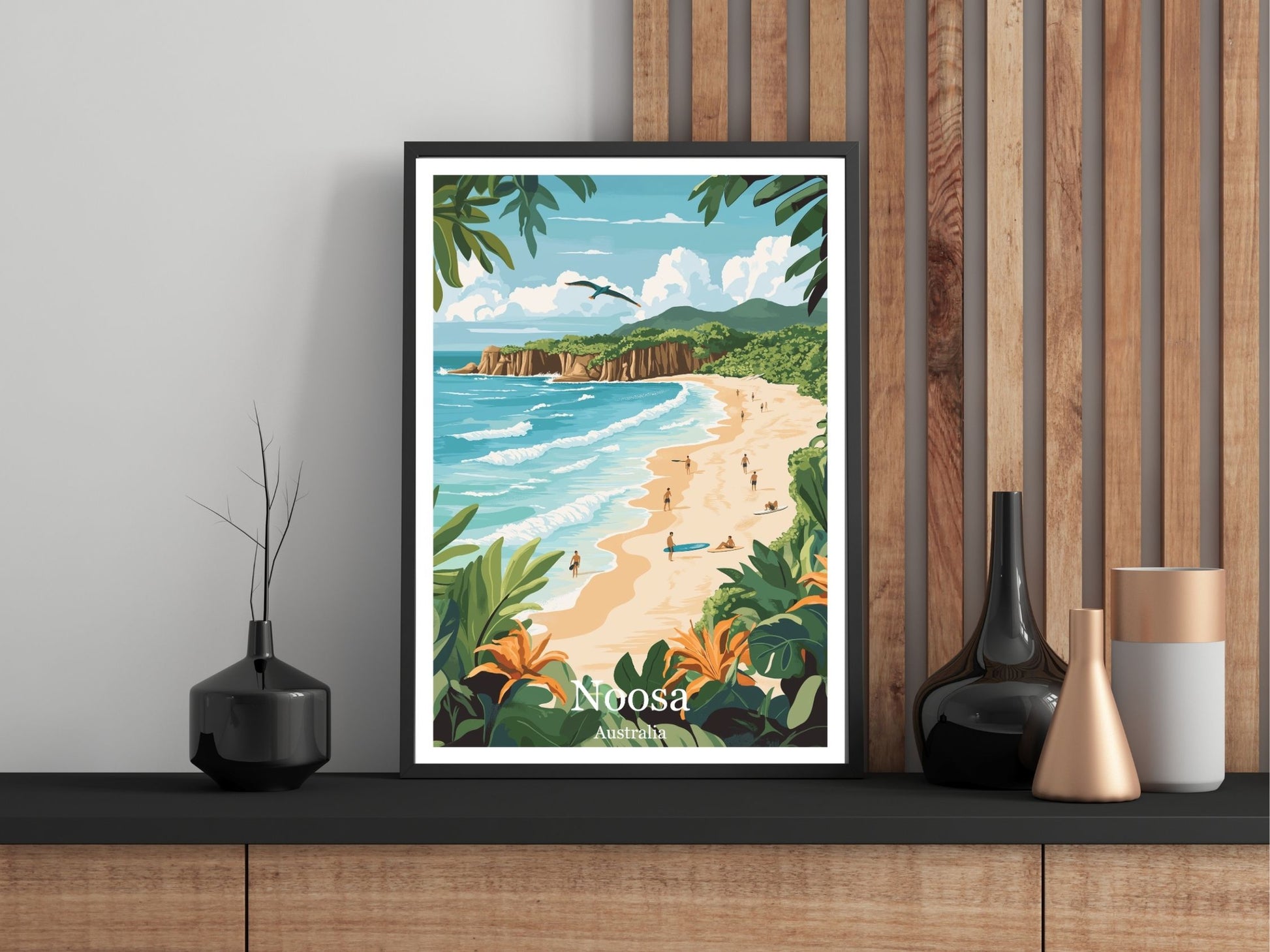 Framed artwork of a beach scene with 'Noosa' on a wall.